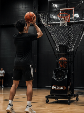 An athlete shooting into a Dr. Dish rebounding machine.