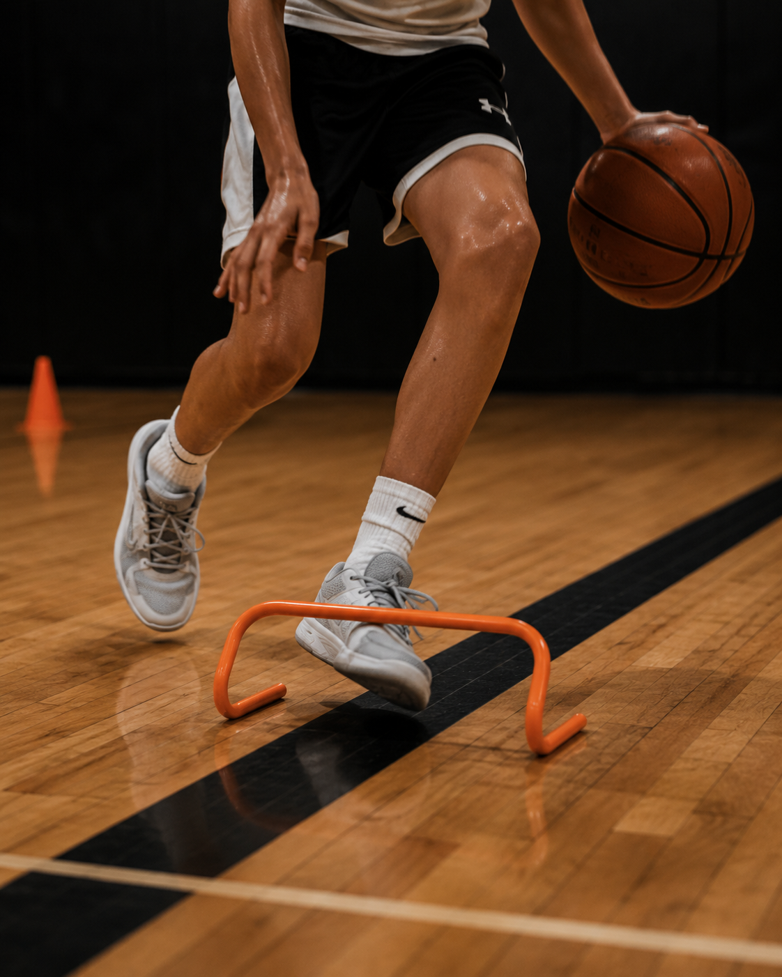 A young athlete dribbling through an agility hurdle drill.