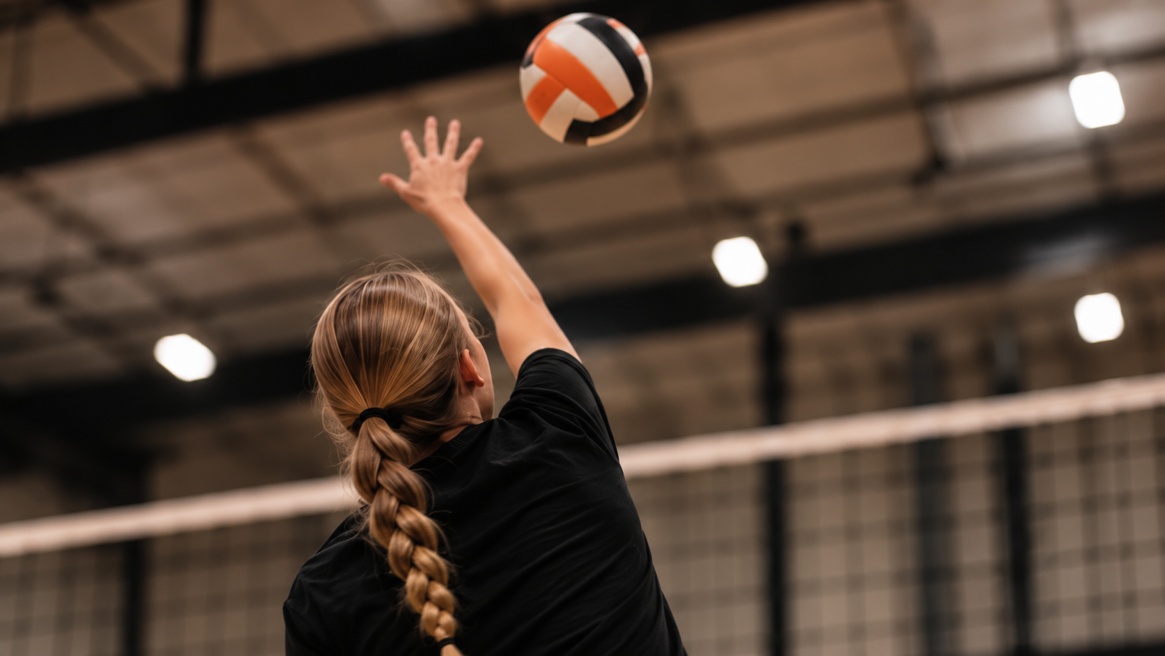 An athlete mid-serve, reaching up for the ball.